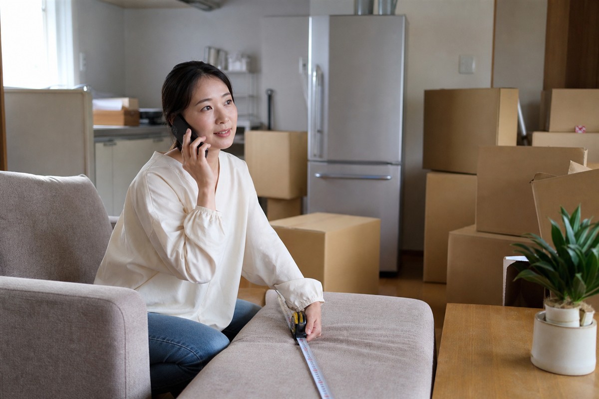 引越し前の不用品回収について電話相談する日本人女性