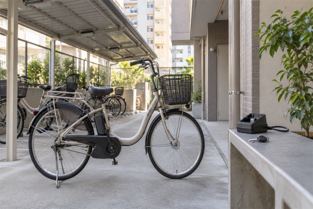 大阪市内の駐輪場にある電動アシスト自転車と鍵・充電器