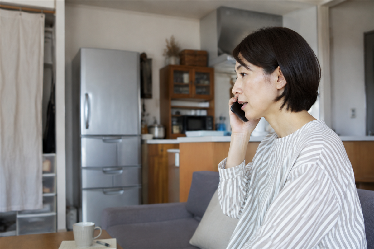 冷蔵庫を背景に回収方法を電話で確認する様子