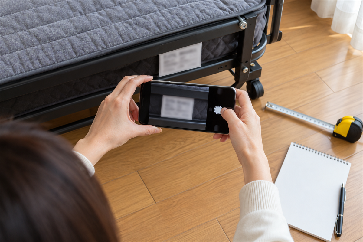 折りたたみベッドの型番と採寸情報をそろえる手元